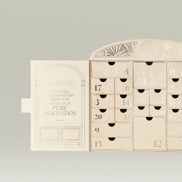 Tropic advent calendar open showing 24 numbered drawers with botanical detailing beside the lid reading 