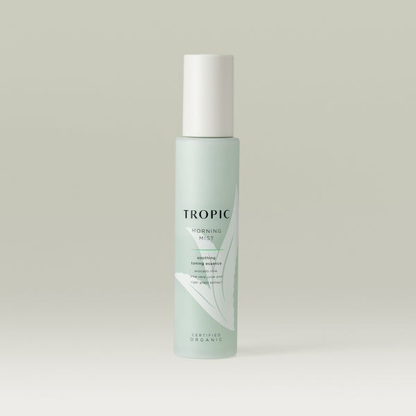 Tropic Morning Mist soothing toning essence. Contains avocado milk, aloe vera juice and tiger grass extract. Certified Organic.
Glass light green bottle with white lid.  Aloe vera plant design features behind black text.